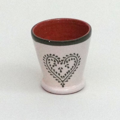 Copo cerâmico branco com interior vermelho e padrão de coração preto