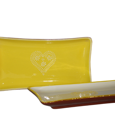 Dois pratos retangulares de cerâmica, um amarelo com padrão branco de coração e outro branco com borda amarela e base castanha.
