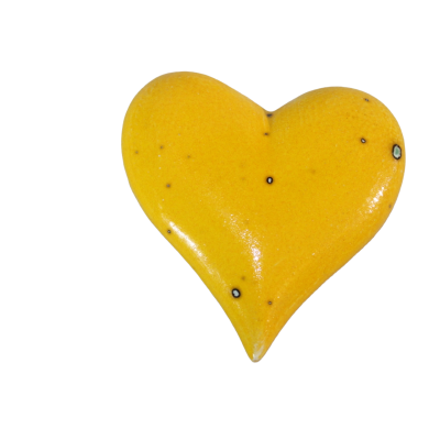 Coração amarelo em cerâmica com manchas pretas e fundo preto