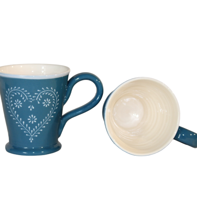 Duas canecas de cerâmica azul e creme com padrão de coração branco