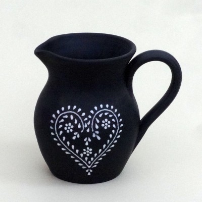 Jarra preta de cerâmica com padrão branco de coração e flores