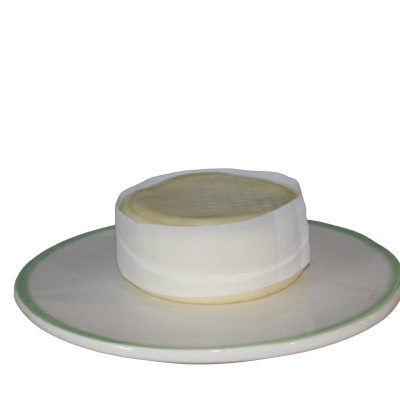 Queijo redondo branco envolto em pano branco num prato branco com borda verde