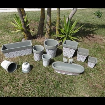 Conjunto de vasos de cerâmica cinza com padrão geométrico branco e rosa em relva ao ar livre