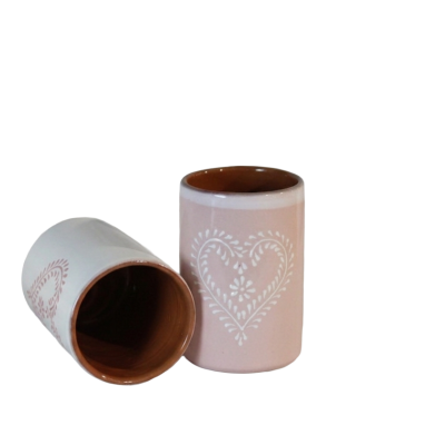 Duas canecas cerâmicas rosa e branca com padrão de coração branco
