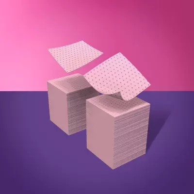 Blocos de papel cor-de-rosa com padrão de pontos escuros em fundo rosa e superfície roxa