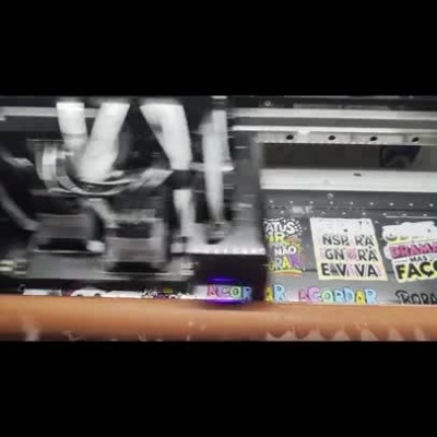 Impressora a produzir e aplicar adesivos coloridos com frases e personagens de anime