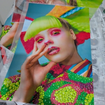 Folhas impressas com imagens de moda coloridas, rosto de mulher com cabelo verde e roupa estampada