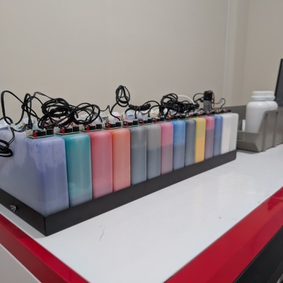 Frascos coloridos de tinta retangulares transparentes com circuitos eletrónicos e fios