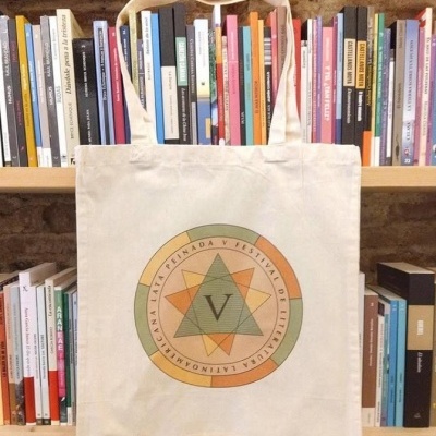 Saco de tecido bege com estampa circular colorida e letra V no centro