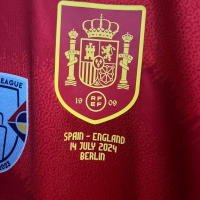 Camisola de futebol vermelha da seleção espanhola com brasão e texto de jogo entre Espanha e Inglaterra