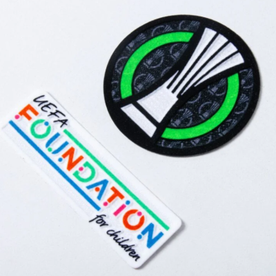 Dois autocolantes, um redondo com desenho abstrato e outro retangular com texto colorido