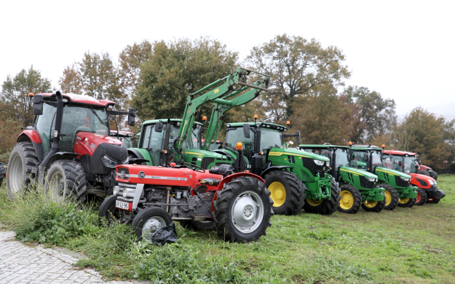 linha de tratores agrícolas coloridos estacionados num campo