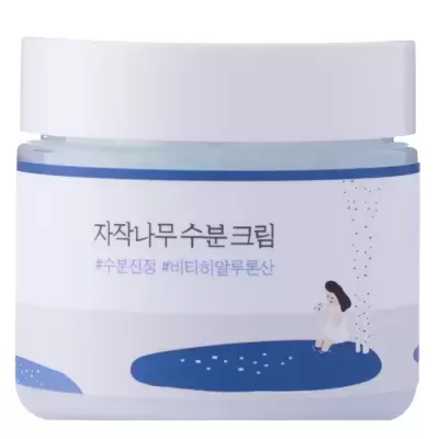 Frasco de creme hidratante com tampa branca e rótulo branco e azul com texto em coreano e ilustração