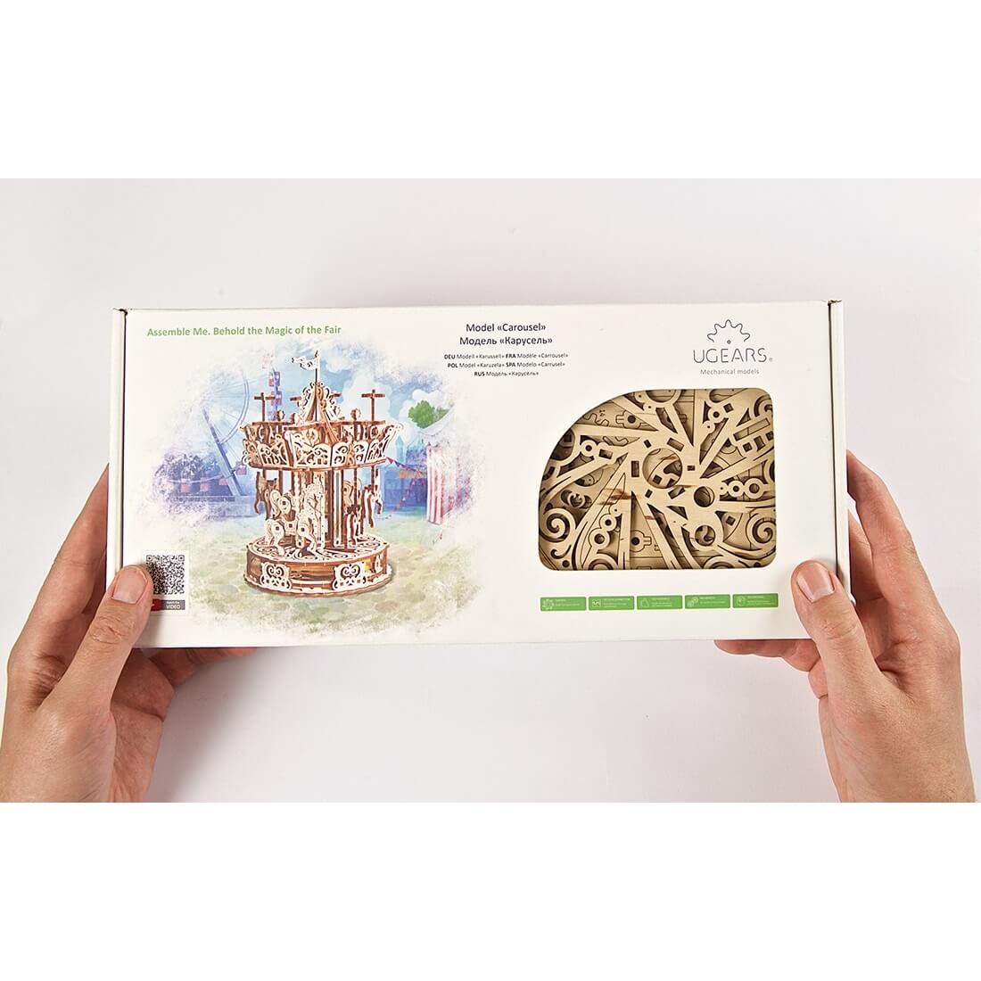 Puzzle 3D - Modelo mecânico Carrossel Embalagem para modelo mecânico 3D de carrossel em madeira UGEARS com janela das peças à mostra.