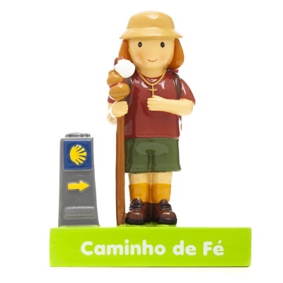Figurina de peregrino com bastão e placa de caminho em base verde com texto 