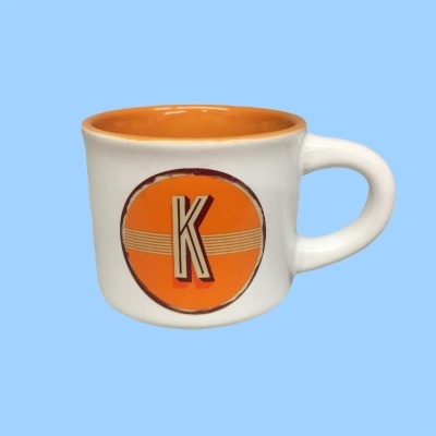 Caneca branca com interior laranja e letra K em círculo laranja
