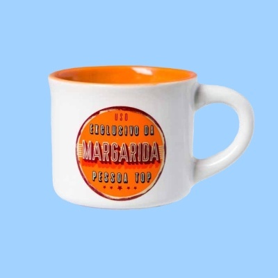 Caneca branca com interior laranja e texto decorativo em círculo laranja