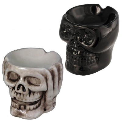 Dois cinzeiros cerâmicos em forma de caveira, um preto e outro branco com detalhes castanhos.