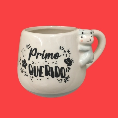 Caneca branca com texto 'Primo Querido' e figura de urso na asa