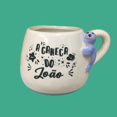 Caneca branca com texto e animal marinho em relevo na alça