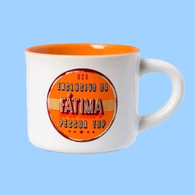 Caneca branca com interior laranja e texto em etiqueta circular laranja