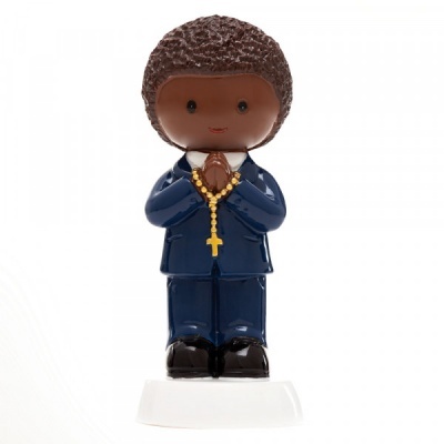 Figura decorativa de menino com roupa azul e colar com cruz.