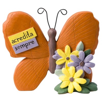 Objeto decorativo de borboleta laranja com flores e texto acredita sempre