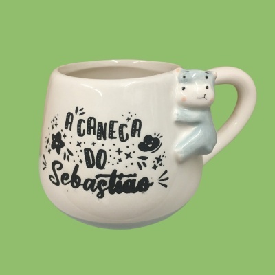 Caneca branca com pega em forma de urso azul e texto decorativo