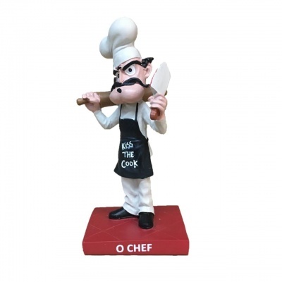 Estatueta de chef com avental preto e chapéu branco segurando faca e rolo de massa