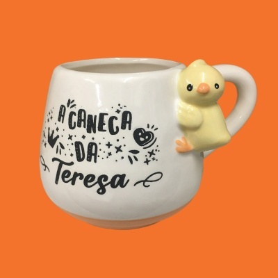 Caneca branca com texto preto e puxador em forma de pintainho amarelo
