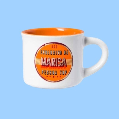 Caneca branca com interior laranja e texto decorativo na frente
