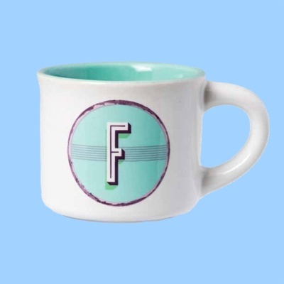 Caneca branca com interior azul claro e letra F no centro