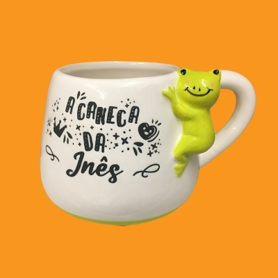 Caneca branca com sapo verde e texto À CANECA DA Inês
