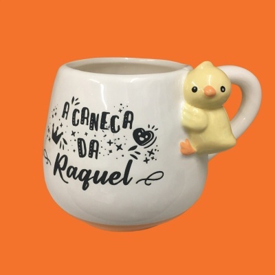 Caneca branca com texto preto e puxador de patinho amarelo