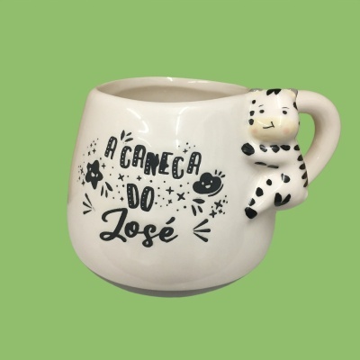 Caneca branca com texto preto e figura de vaca na pega