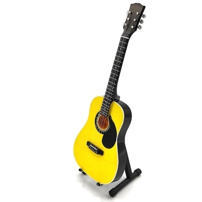 Guitarra acústica amarela apoiada num suporte preto