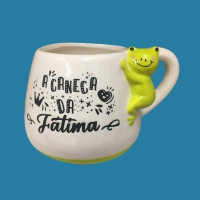 Caneca branca com texto e sapo verde como alça