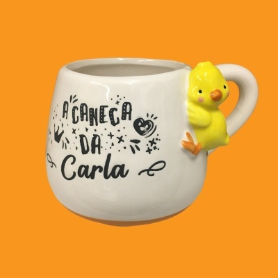 Caneca branca com texto 'A CANECA DA Carla' e pintainho amarelo no punho