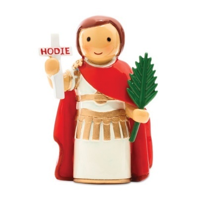 Estatueta de figura masculina com túnica branca, capa vermelha e cruz com texto HODIE