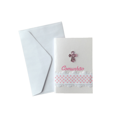 Cartão de comunhão branco com fita rosa e cruz decorativa ao lado de um envelope branco