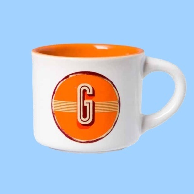 Caneca branca com interior laranja e letra G em círculo laranja