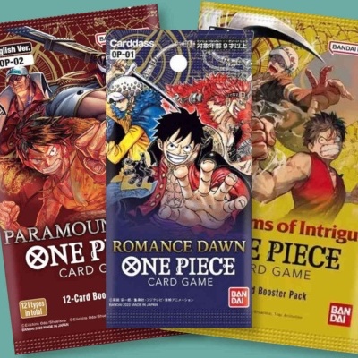 Três packs coloridos de cartas do ONE PIECE CARD GAME com personagens do anime