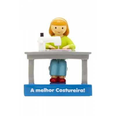 Miniatura de mulher a costurar com máquina de costura branca sobre mesa cinzenta