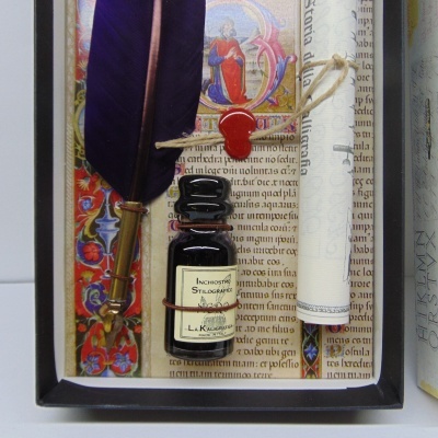 Conjunto de escrita com pena roxa, tinteiro preto e pergaminho enrolado numa caixa decorativa