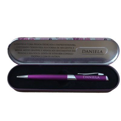 Caneta roxa personalizada com nome Daniela numa caixa metálica prateada