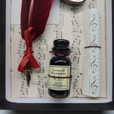 Conjunto vintage com tinteiro, pena de escrever borgonha e folhas planeadas com pauta musical