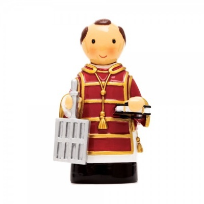 Figura decorativa de cerâmica de um soldado com casaco vermelho segurando uma gaiola e um livro.