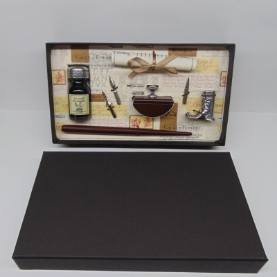 Conjunto vintage de escrita com tinta, quatro penas, tinteiro, caneta de madeira e rolo de papel numa caixa preta aberta.