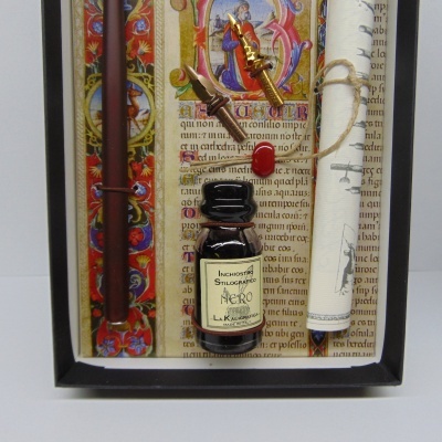 Conjunto de escrita antiga com tinteiro, pergaminho, pena dourada e caneta castanha numa caixa decorativa.