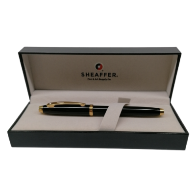 caneta preta com detalhes dourados numa caixa de apresentação preta e bege com logo SHEAFFER